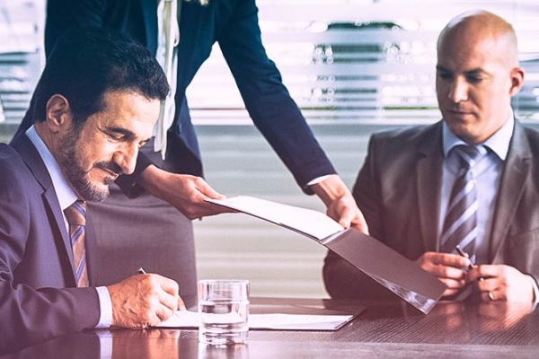 Businessmen signing document