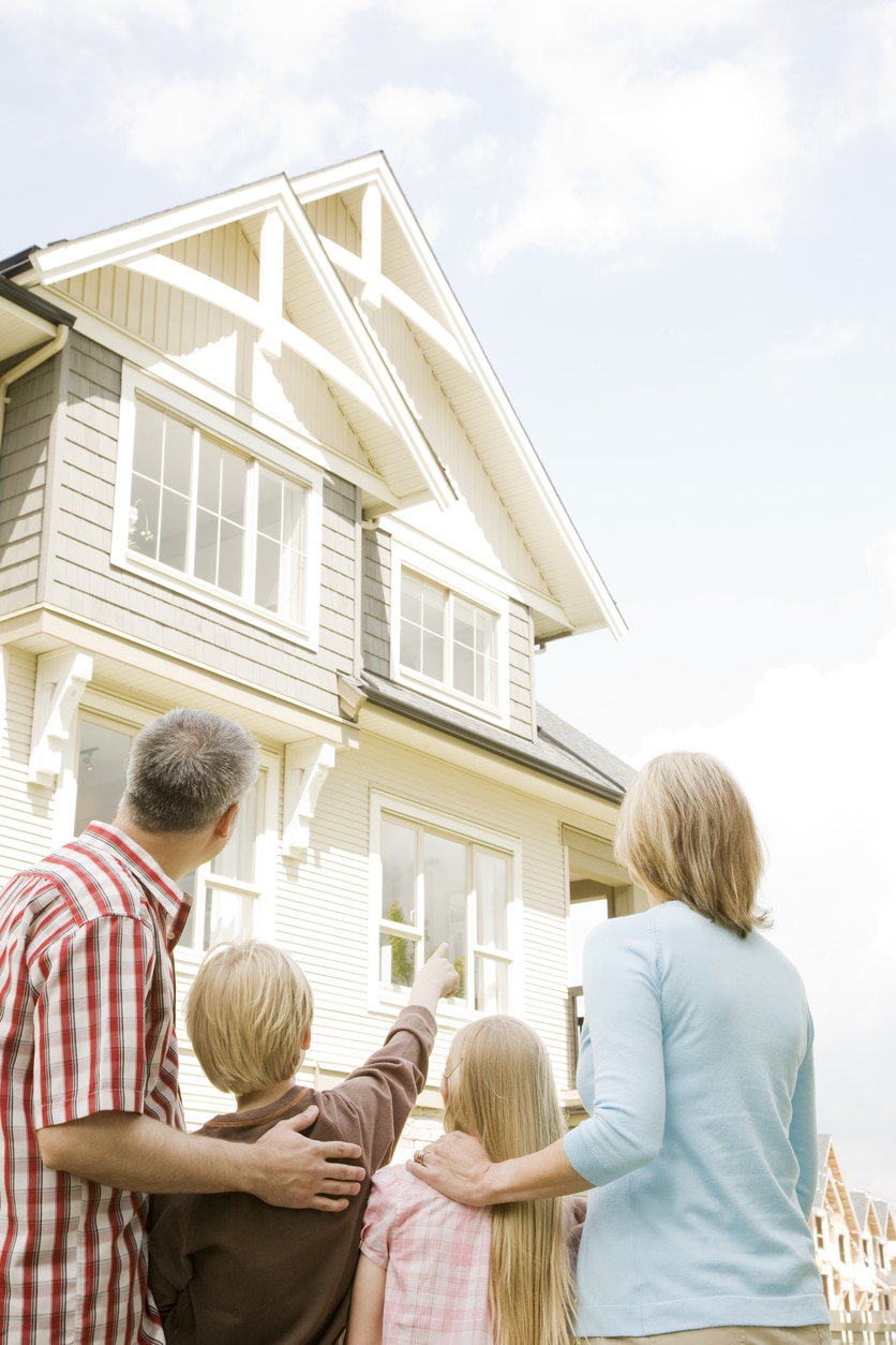 Family looking at surburban home in neighborhood