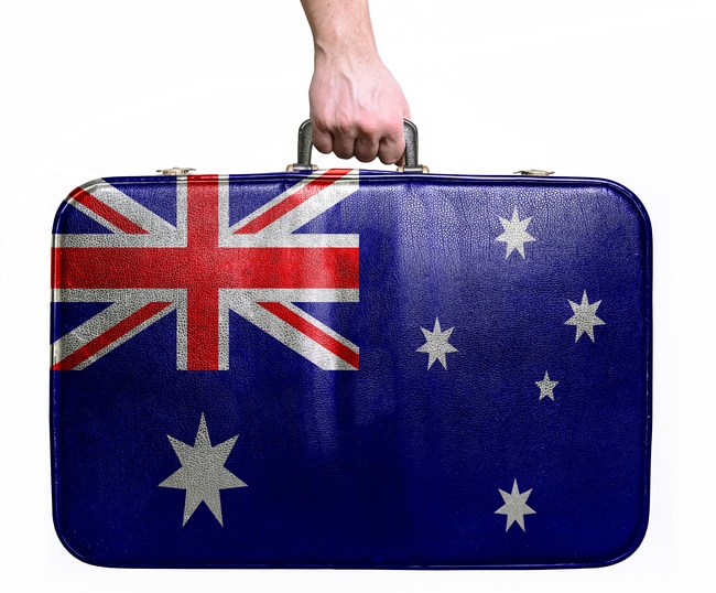 Tourist hand holding vintage travel bag with flag of Australia