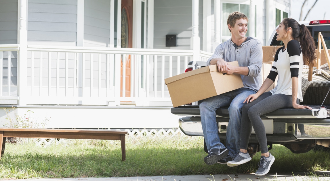 Young couple moving into new home, on pickup truck