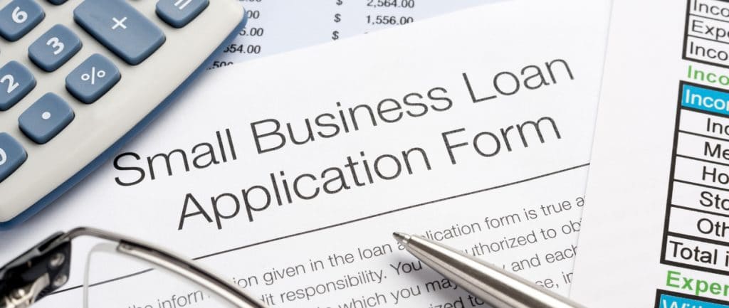 Small Business Loan Application Form With Pen, Calculator