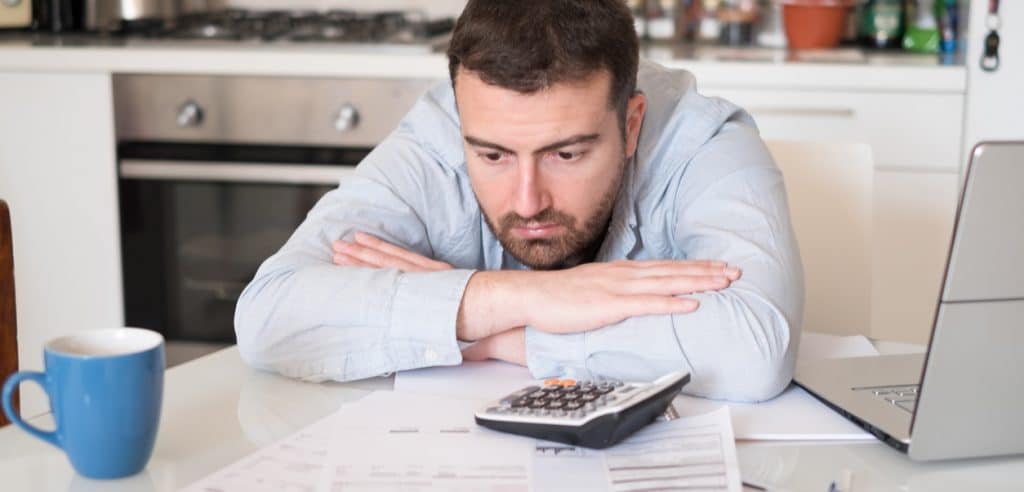 Frustrated Man Calculating Bills And Taxes