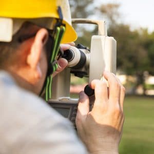 Surveyor Engineer With Partner Making Measure On The Field